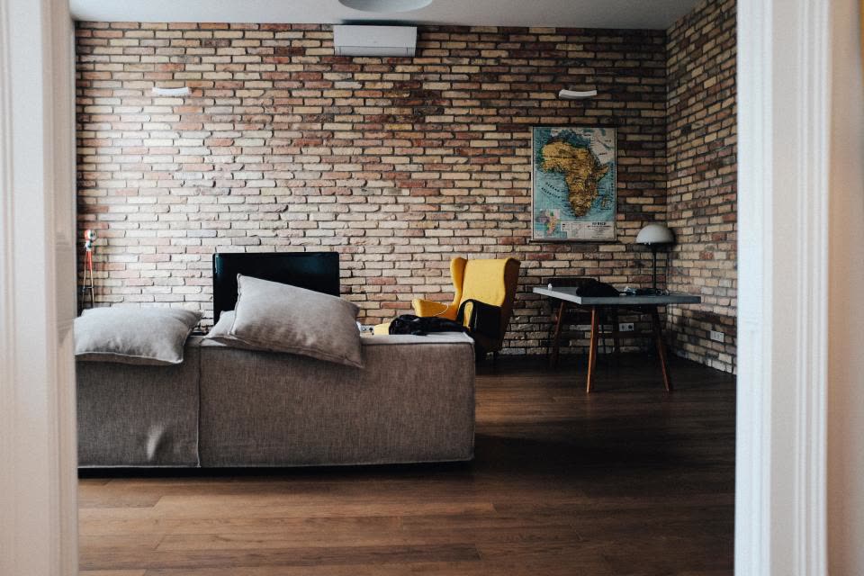 Soggiorno con mattoni a vista e parquet scuro