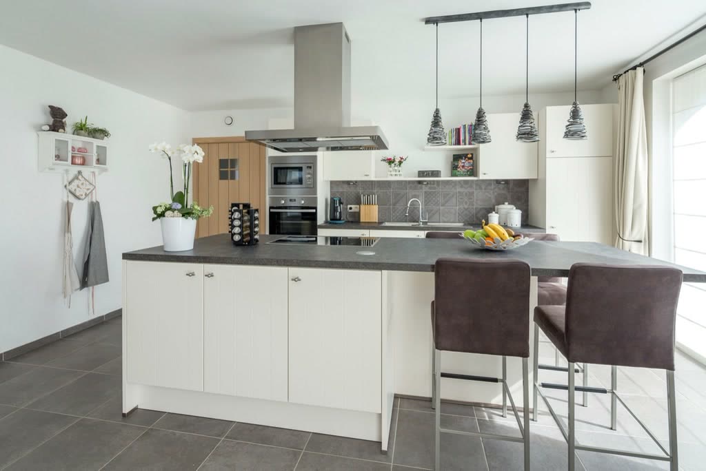 Cucina bianca con isola e lampade a sospensione